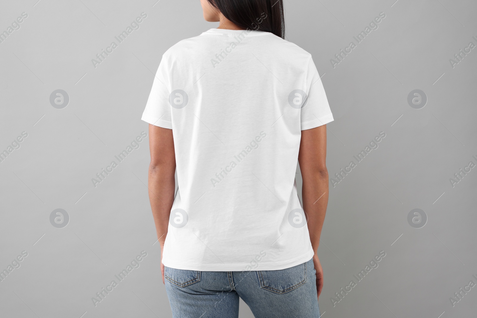 Photo of Woman wearing white t-shirt on light grey background, closeup
