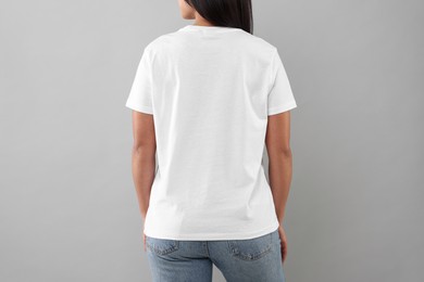 Woman wearing white t-shirt on light grey background, closeup