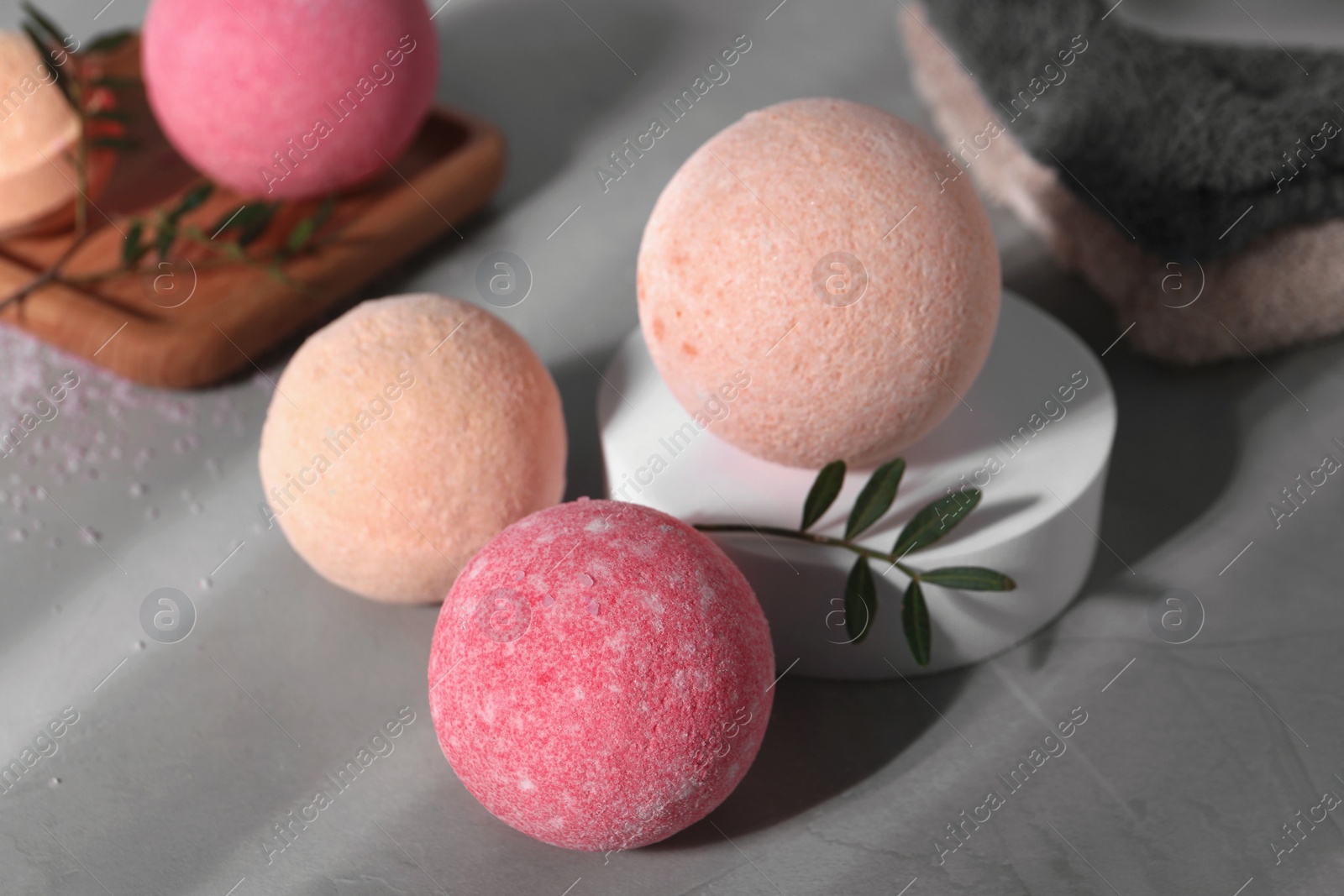 Photo of Beautiful aromatic bath bombs and green twig on grey table