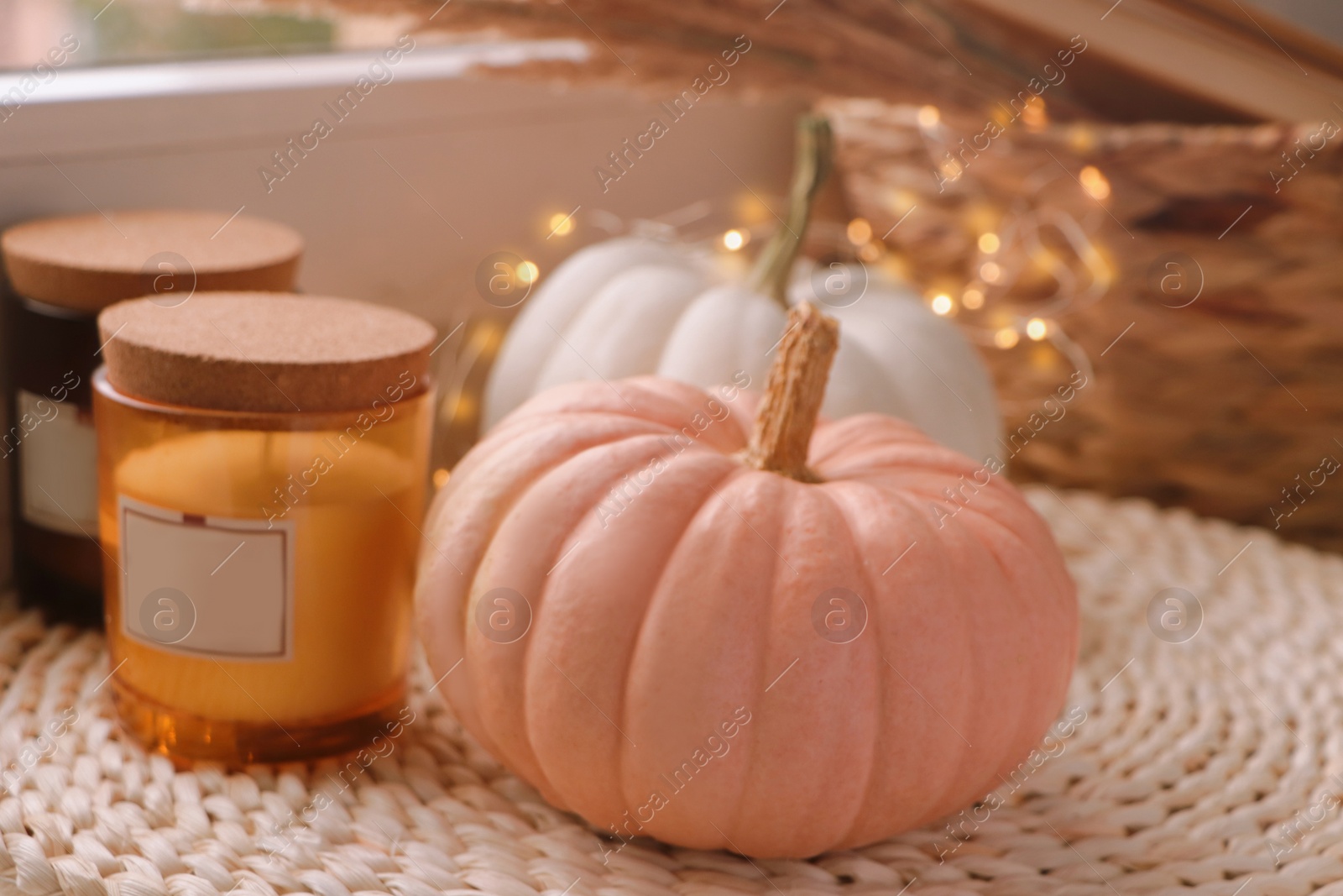 Photo of Pumpkins and candles on window sill indoors