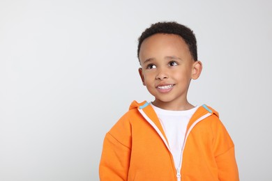 Photo of Portrait of cute African-American boy on light grey background. Space for text