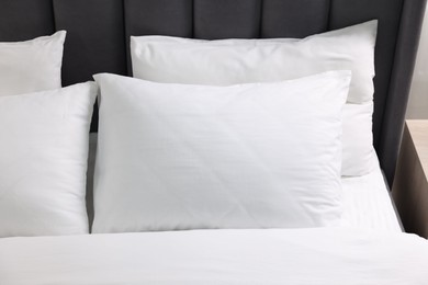 Soft white pillows and duvet on bed, closeup