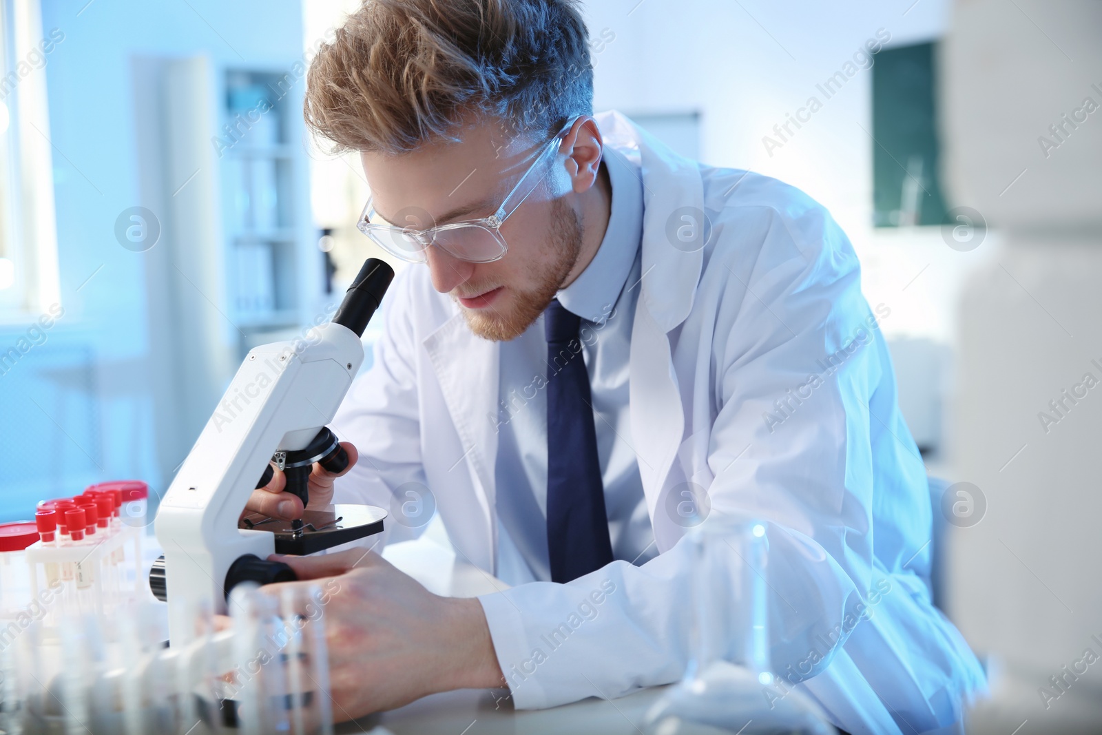 Photo of Male scientist using modern microscope in chemistry laboratory