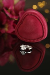 Photo of Beautiful engagement ring against blurred festive lights
