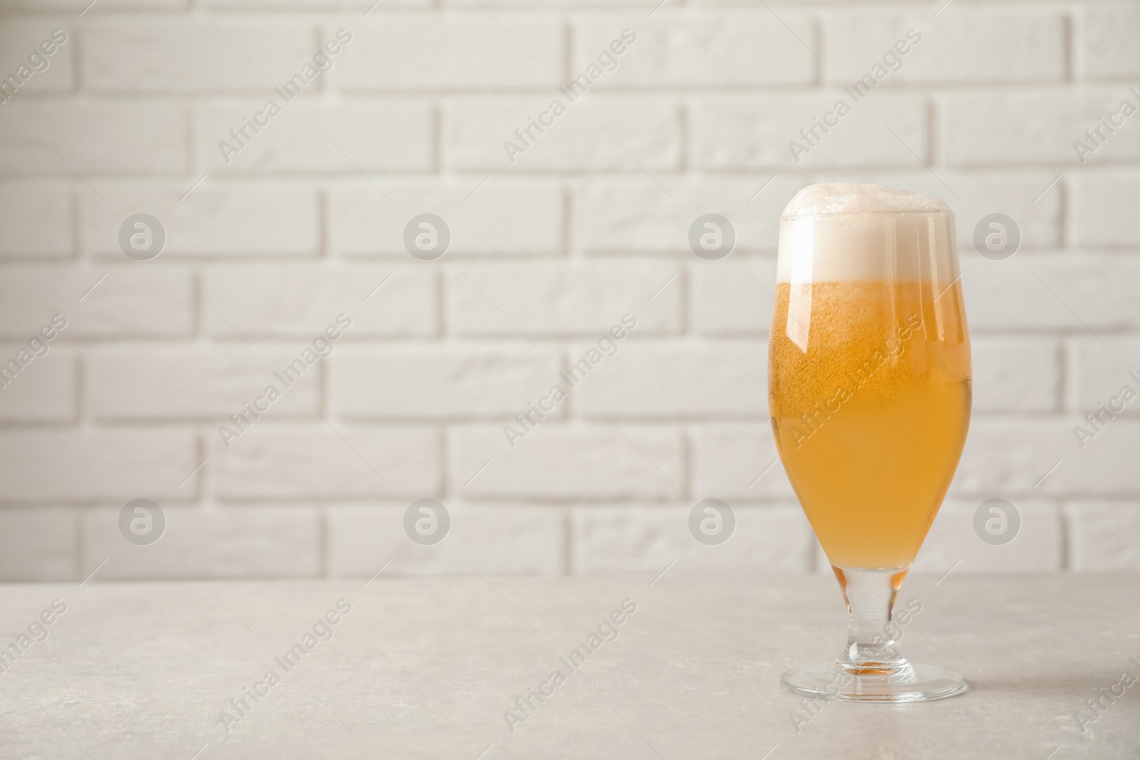 Photo of Glass of cold tasty beer on table