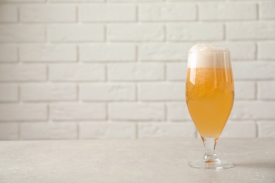 Photo of Glass of cold tasty beer on table