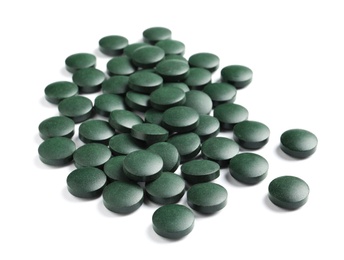 Photo of Spirulina tablets on white background. Healthy lifestyle