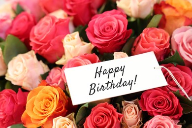 Image of Bouquet of beautiful roses with Happy Birthday card, closeup