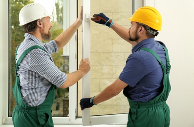 Construction workers installing new window in house