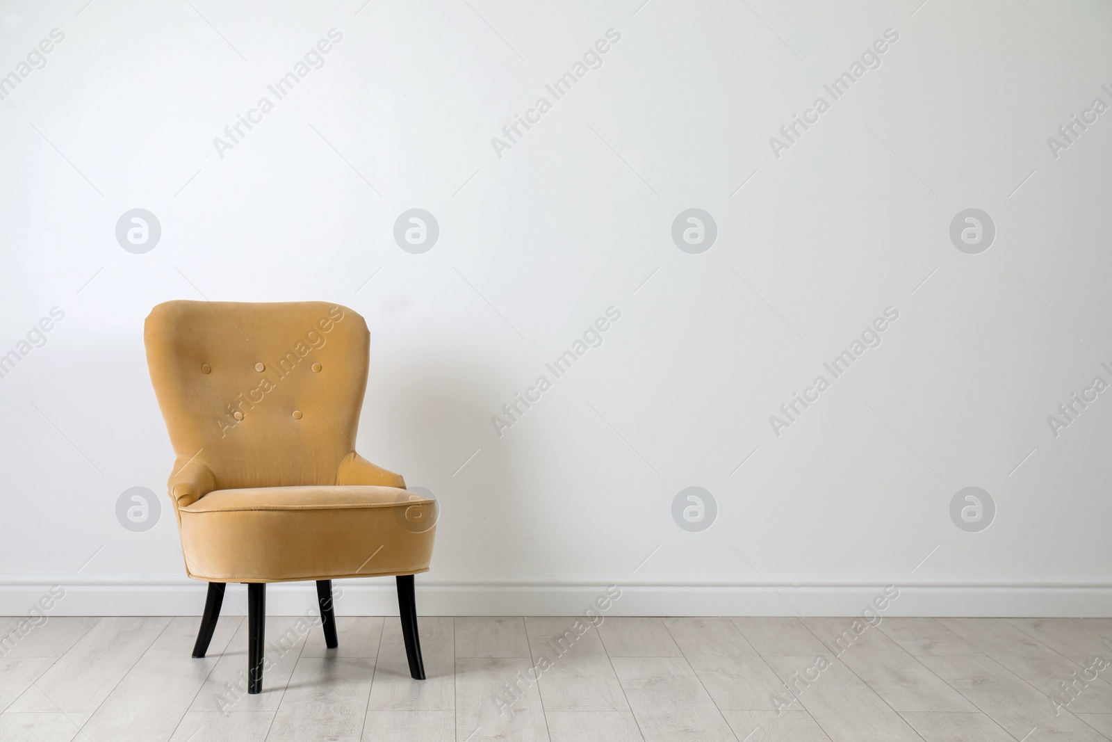 Photo of Stylish comfortable armchair near light wall indoors