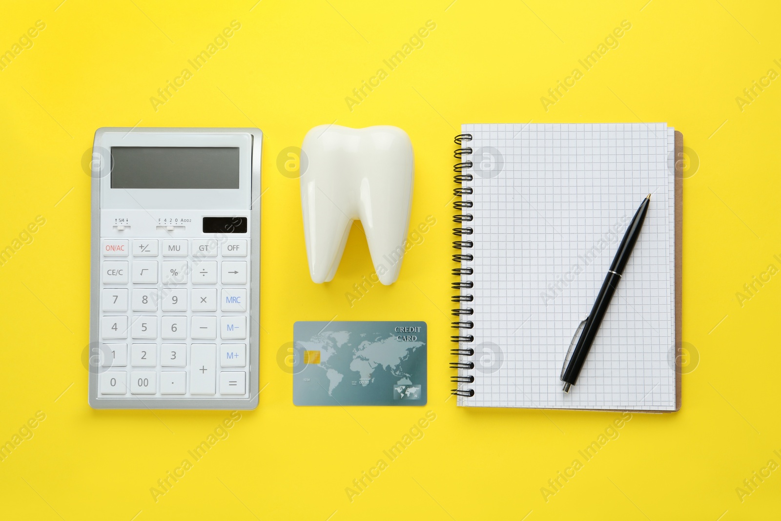 Photo of Flat lay composition with ceramic model of tooth and credit card on yellow background. Expensive treatment