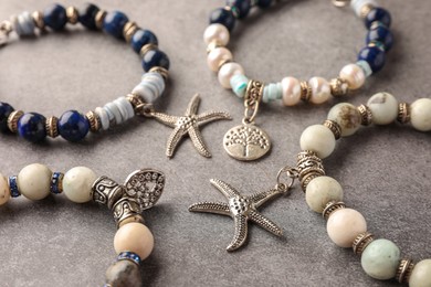 Photo of Different beautiful bracelets with gemstones on grey background, closeup