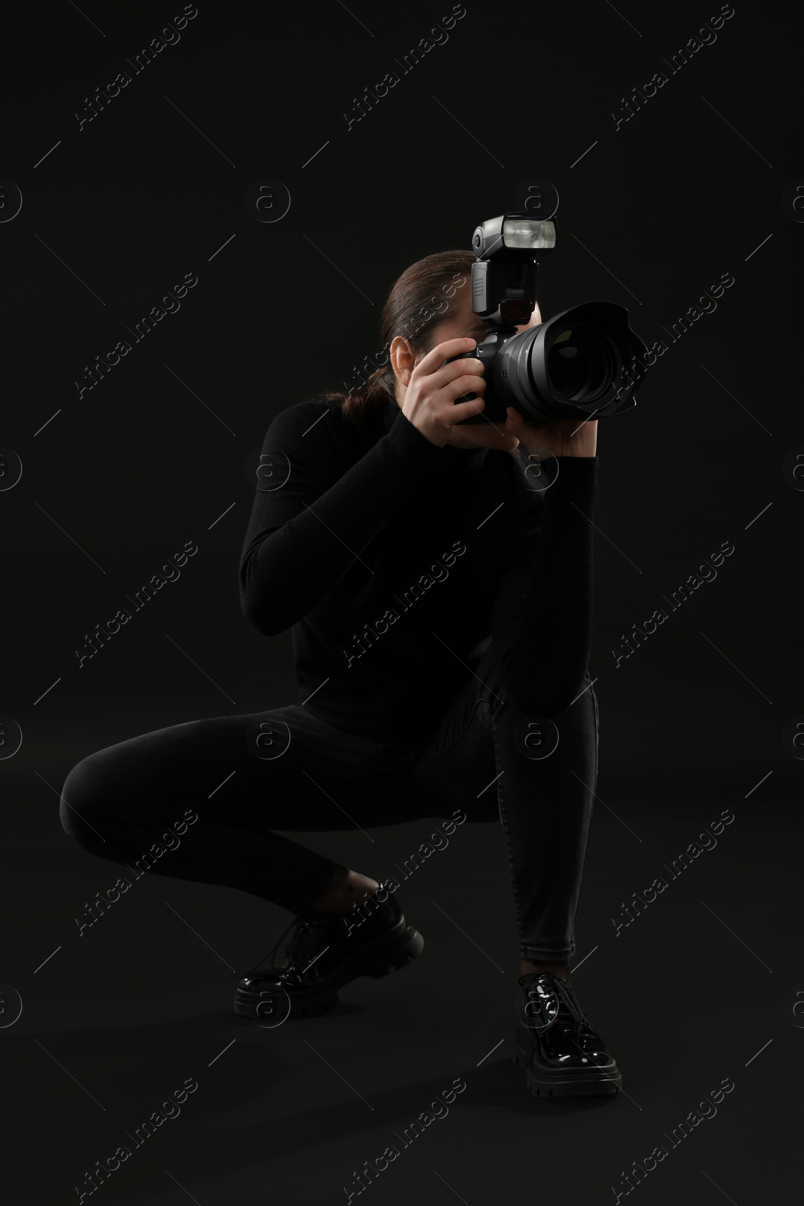 Photo of Professional photographer taking picture on black background