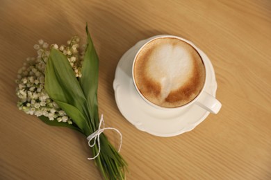 Cup of aromatic morning coffee on wooden table, above view