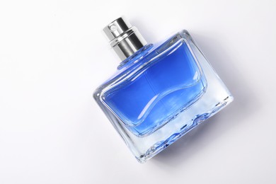 Blue men's perfume in bottle on white background, top view