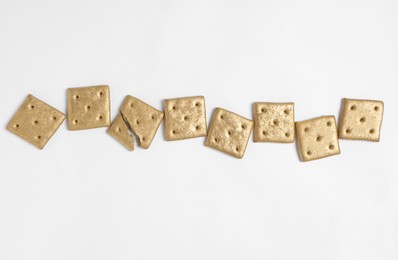 Photo of Shiny golden crackers on white background, top view
