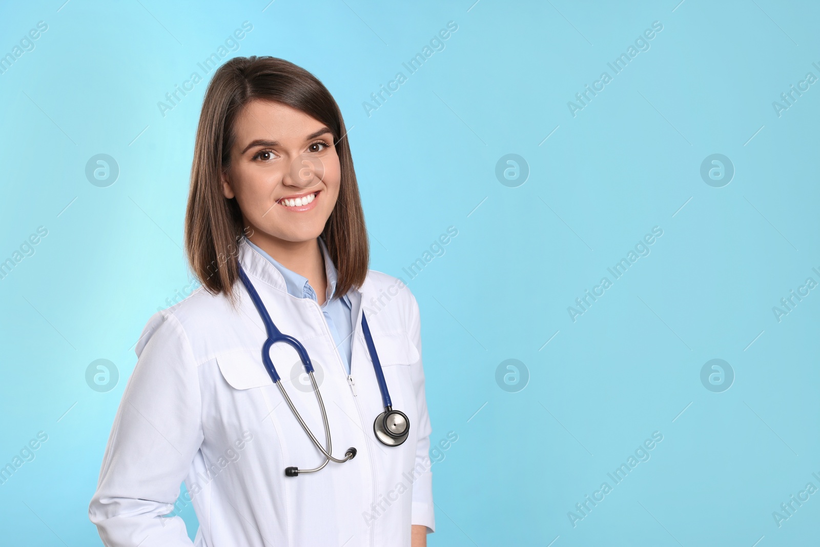 Photo of Pediatrician with stethoscope on light blue background, space for text