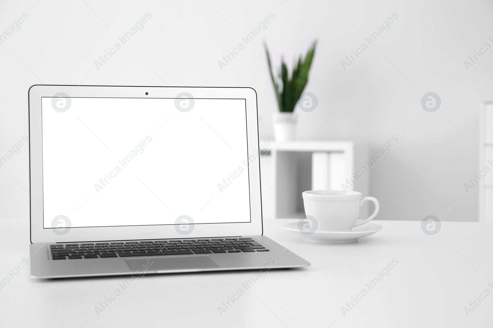 Photo of Comfortable workplace with modern laptop on table in office. Mockup for design