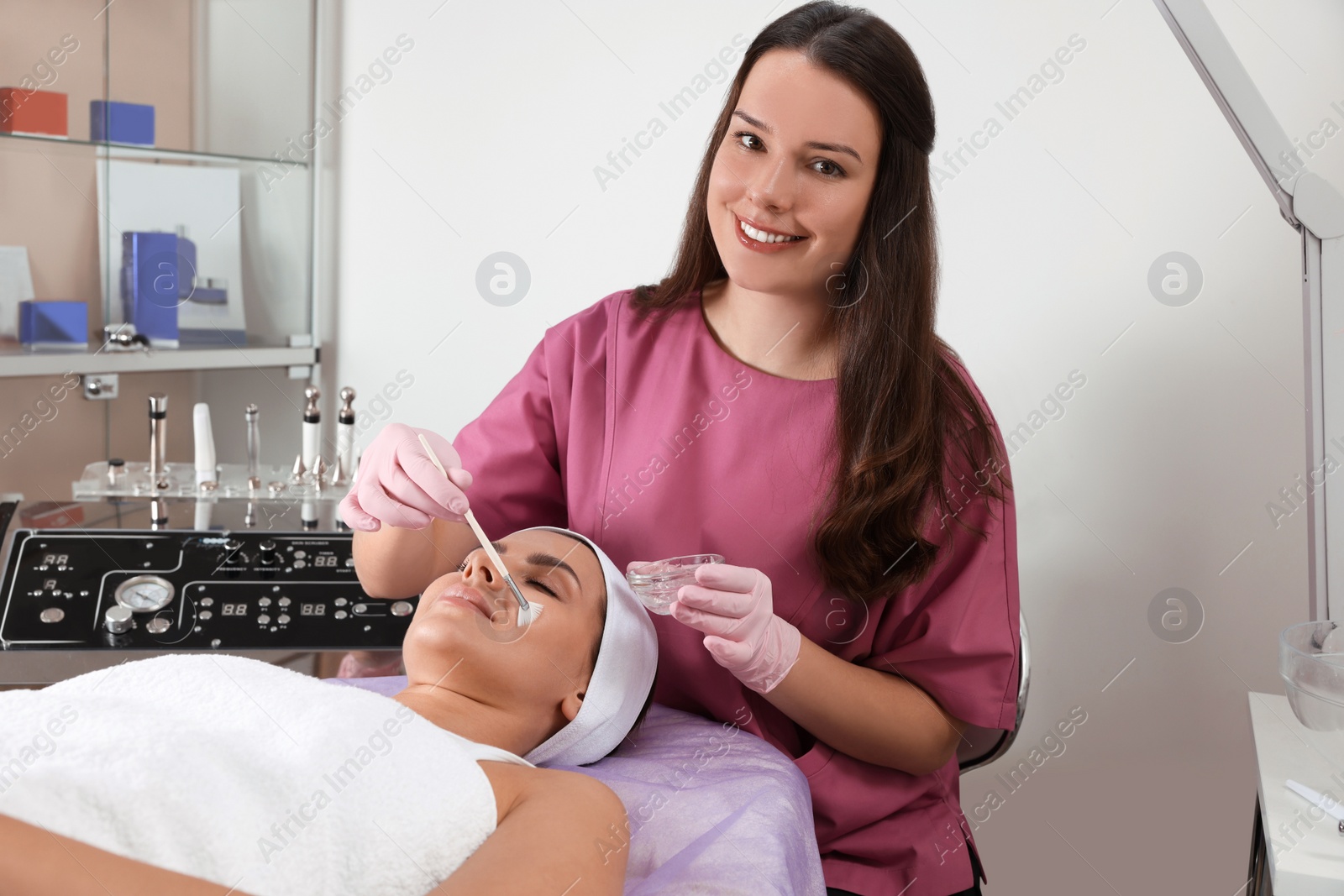 Photo of Young woman undergoing cosmetic procedure in beauty salon