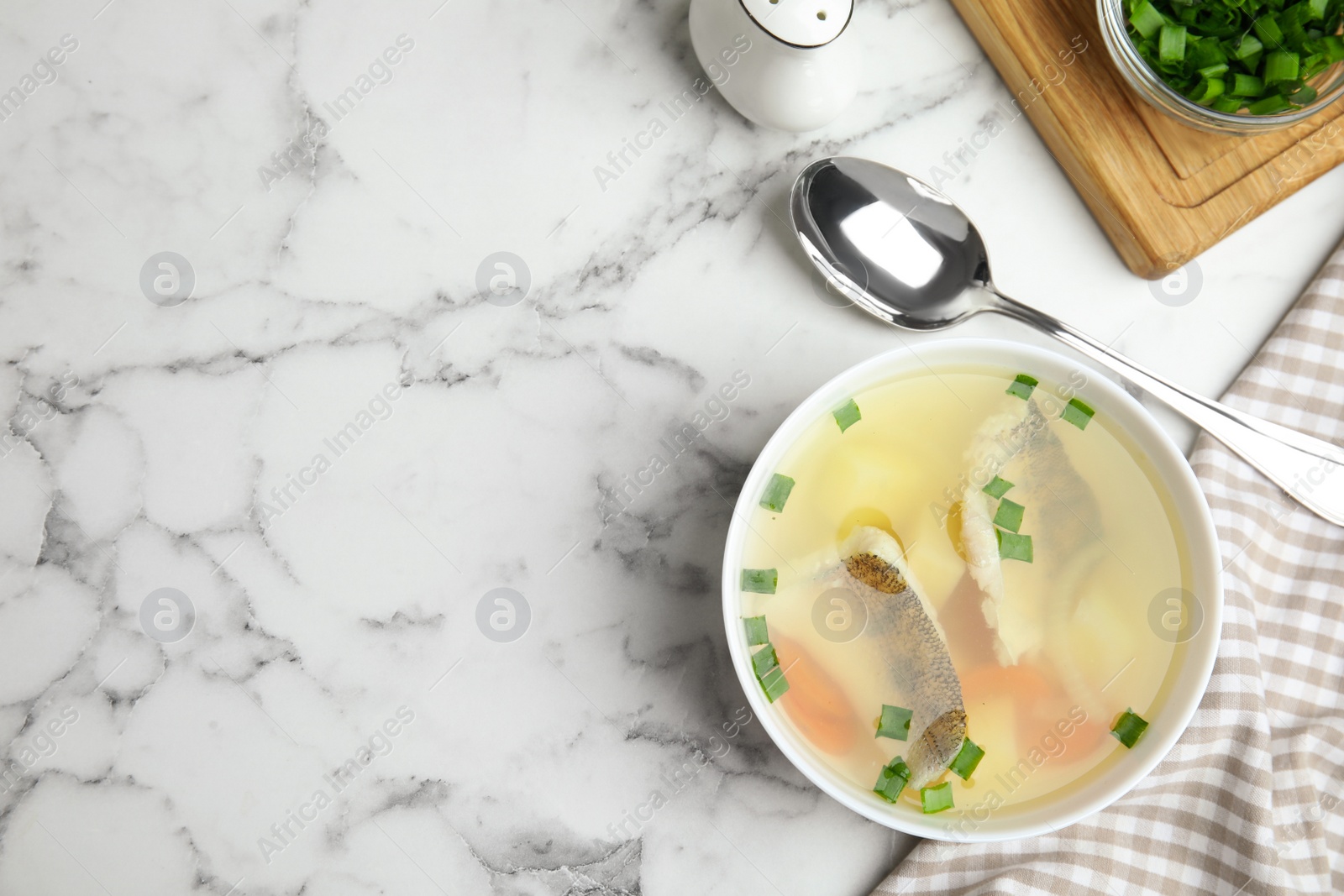 Photo of Delicious fish soup served on marble table, flat lay. Space for text