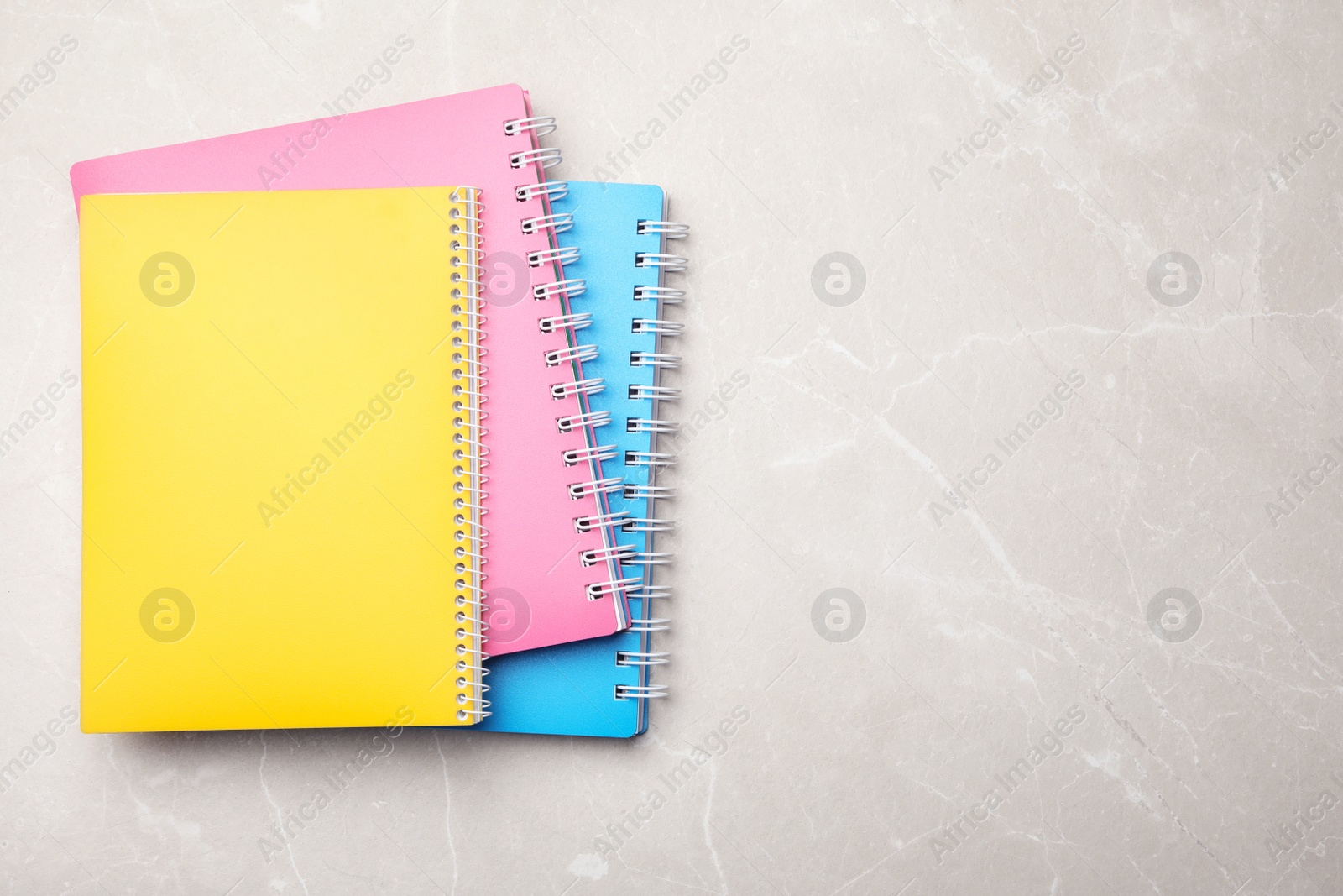 Photo of Stylish notebooks on marble table, top view. Space for text