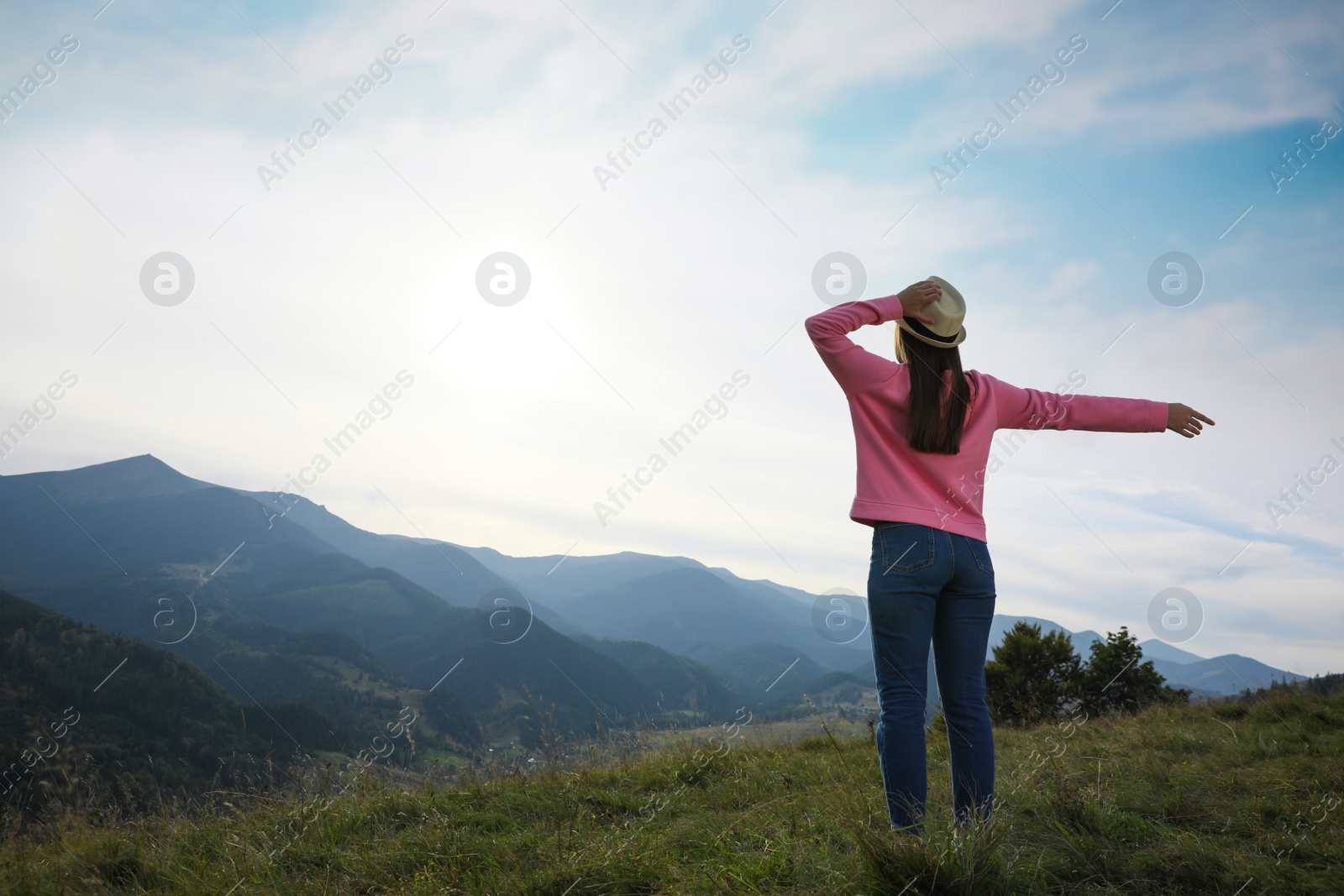 Photo of Woman enjoying mountain landscape, back view. Space for text