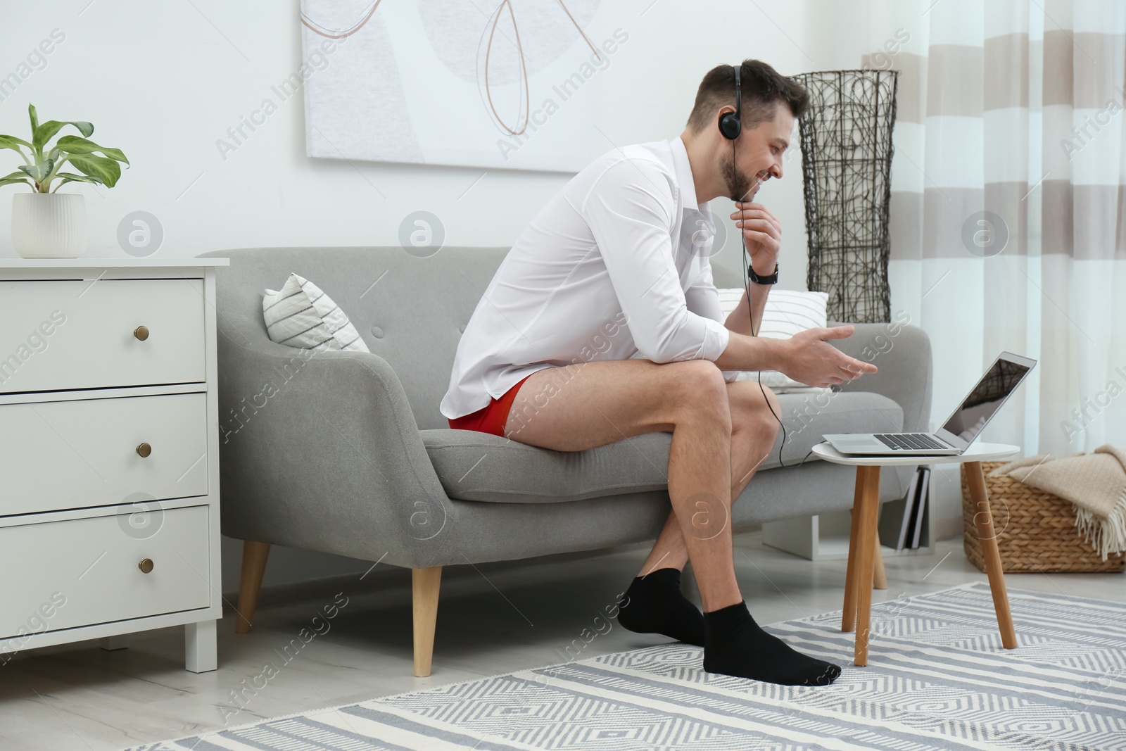 Photo of Businessman in underwear pretending to wear formal clothes during video call at home