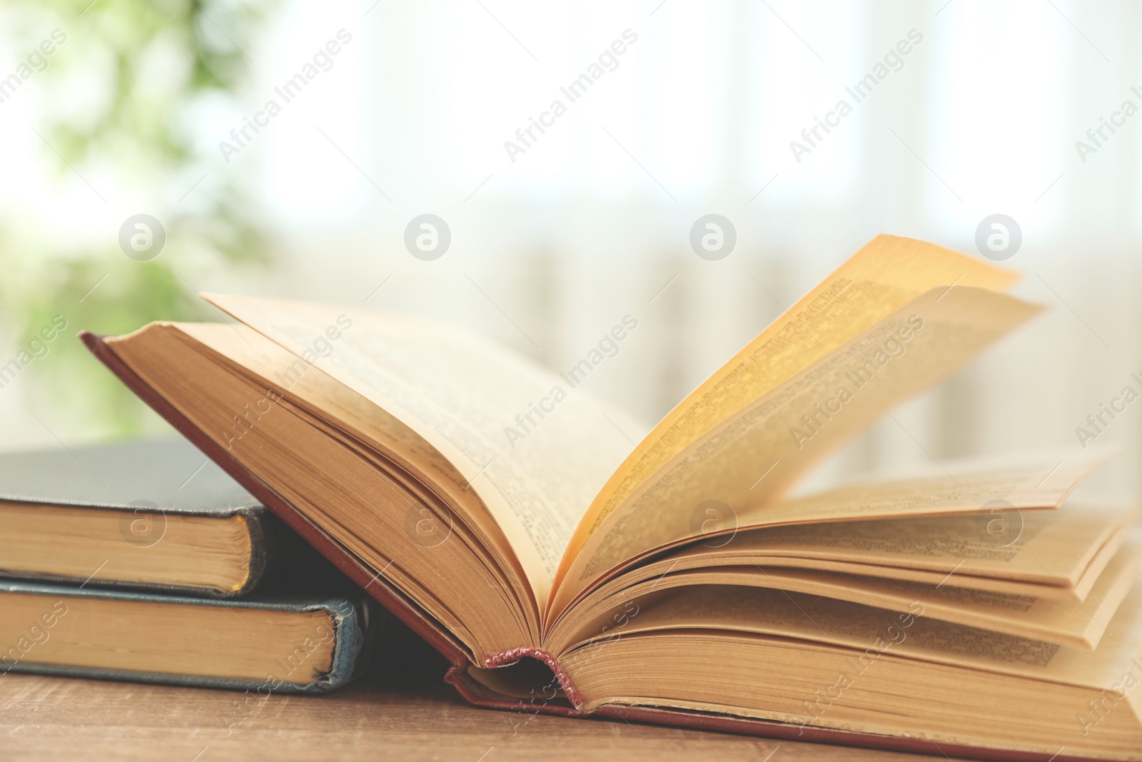 Photo of Open hardcover book on wooden table indoors