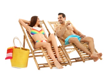 Photo of Young couple on sun loungers against white background. Beach accessories