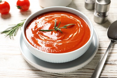 Bowl with fresh homemade tomato soup on wooden table