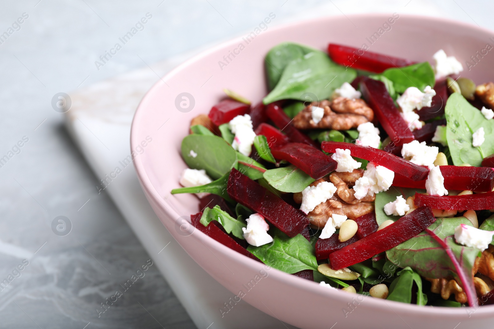 Photo of Delicious beet salad served on grey table, closeup