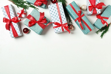 Photo of Christmas gift boxes with red bows on white background, flat lay. Space for text