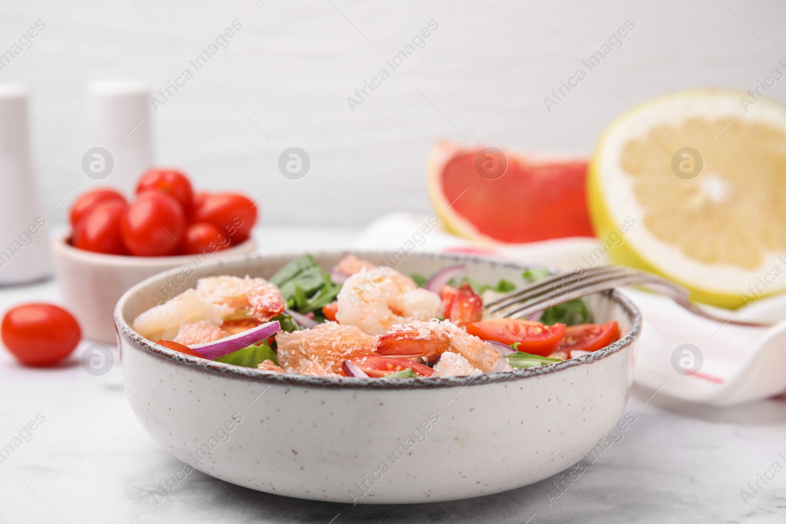 Photo of Delicious pomelo salad with shrimps served on white marble table, closeup