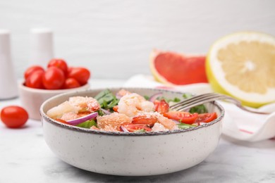 Photo of Delicious pomelo salad with shrimps served on white marble table, closeup