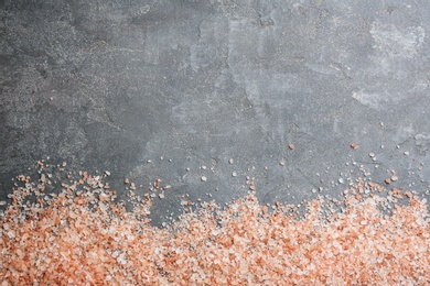 Pink himalayan salt on grey table, flat lay. Space for text