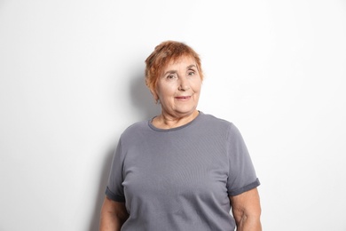 Portrait of elderly woman on light background