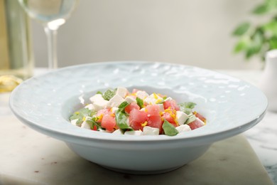 Photo of Delicious salad with watermelon, arugula and feta cheese served on white marble table, closeup