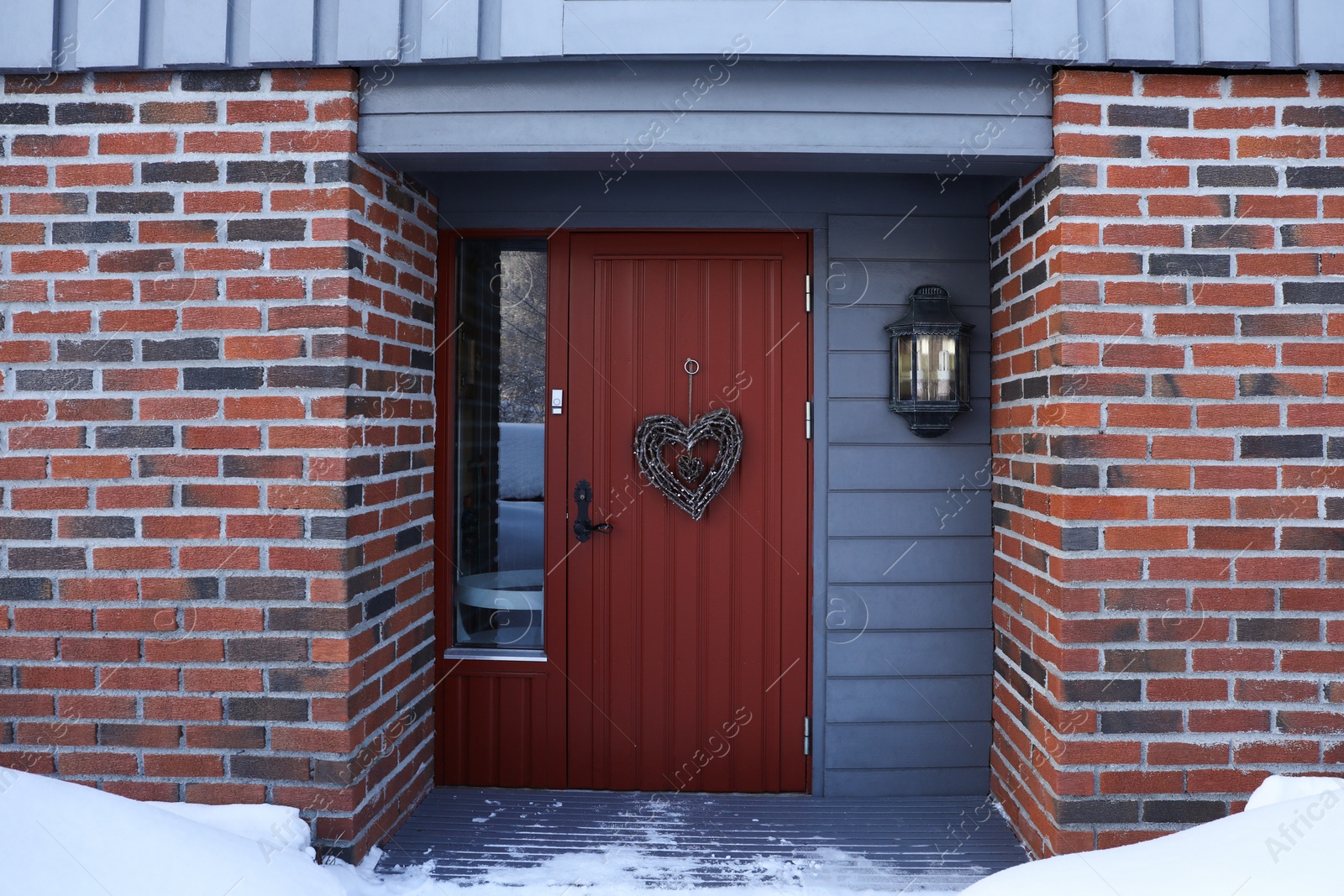 Photo of Beautiful heart shaped wreath made of twigs hanging on door outdoors