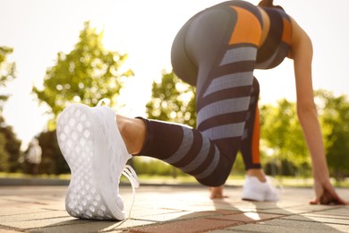 Photo of Woman in fitness clothes ready for running outdoors, low angle view