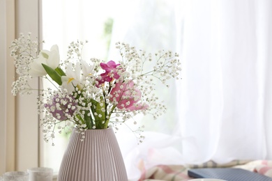 Photo of Beautiful fresh flowers near window indoors, closeup. Space for text