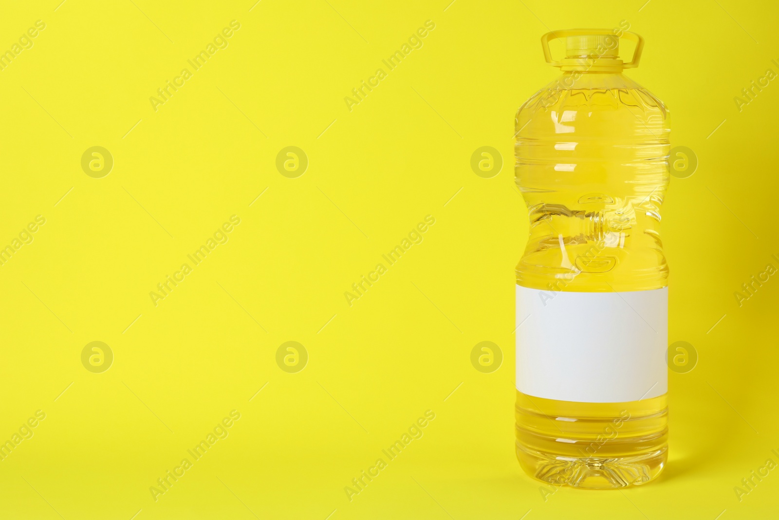 Photo of Bottle of cooking oil on yellow background. Space for text