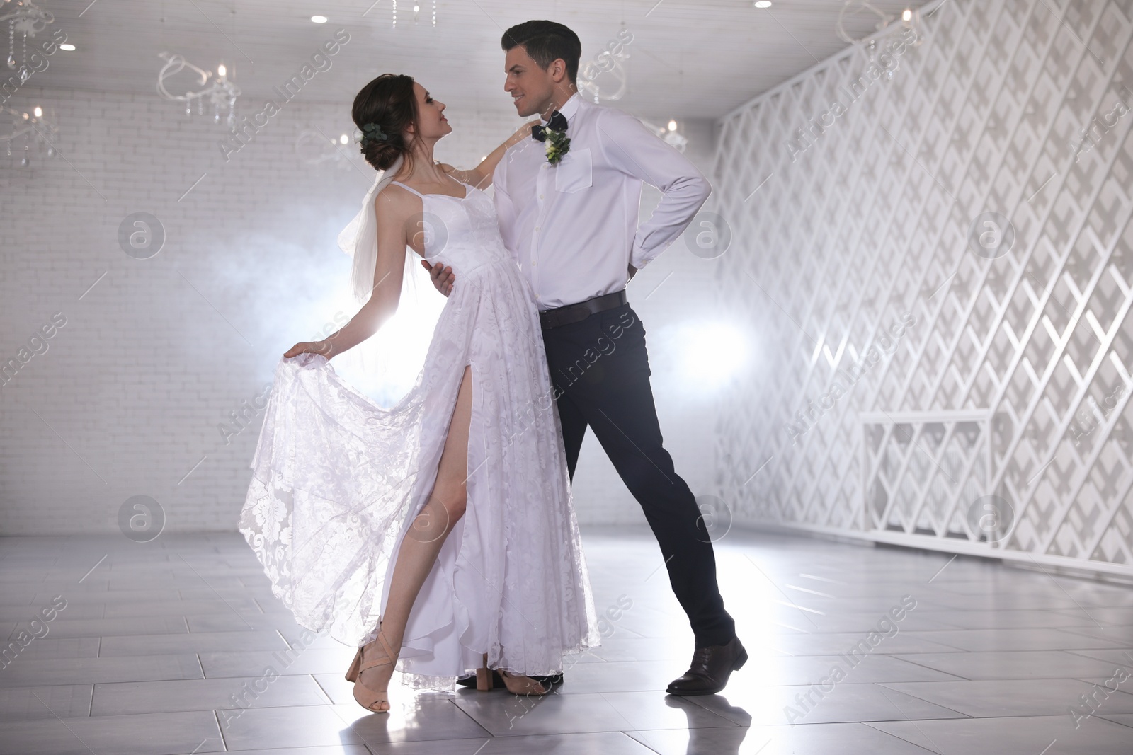 Photo of Happy newlywed couple dancing together in festive hall