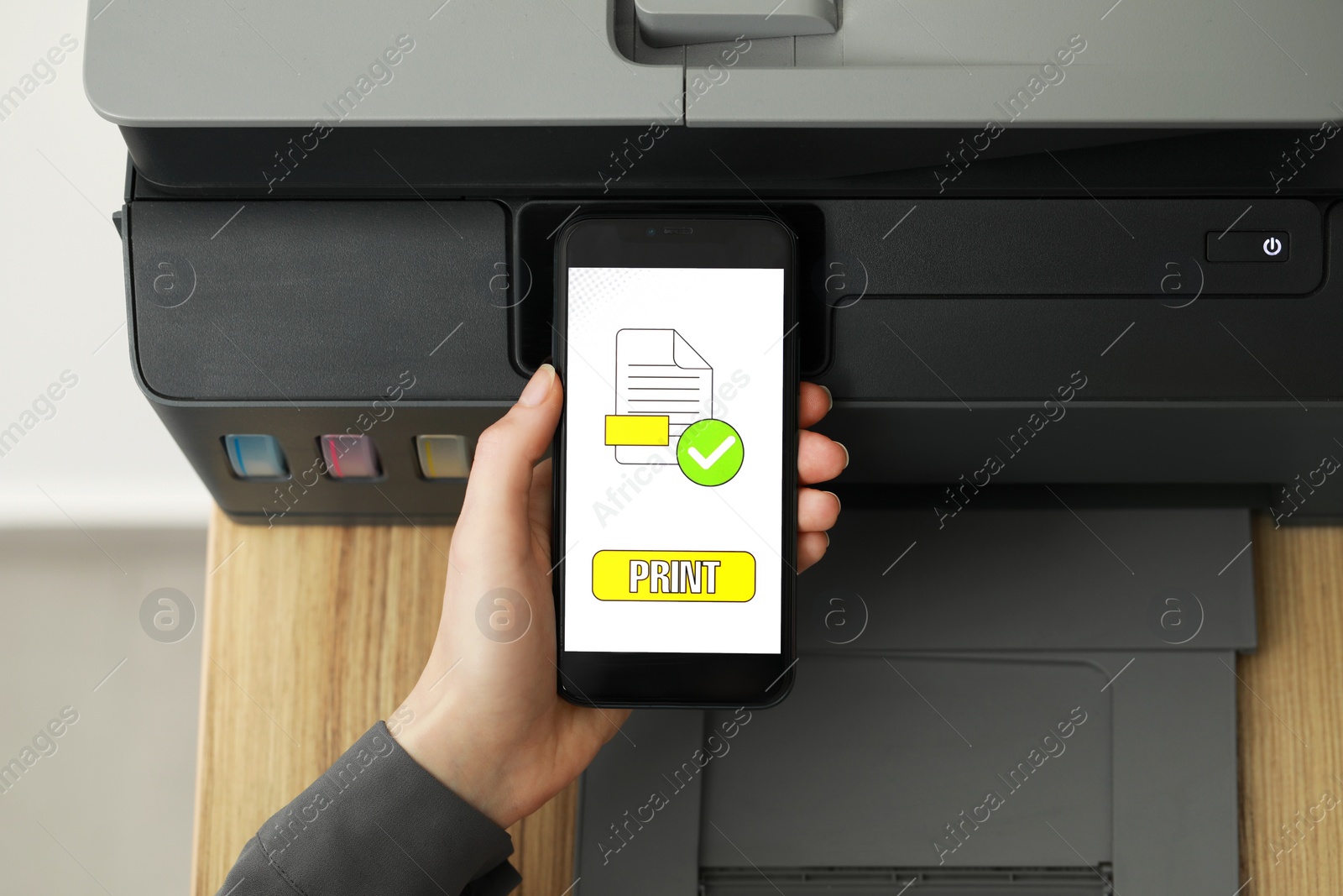 Photo of Woman using printer management application on smartphone indoors, closeup. Image on device screen.