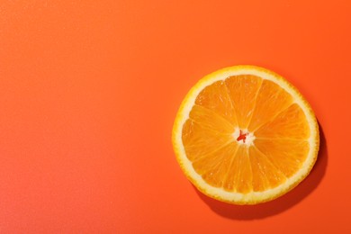 Photo of Slice of juicy orange on terracotta background, top view. Space for text