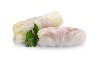Photo of Uncooked stuffed cabbage rolls and parsley isolated on white