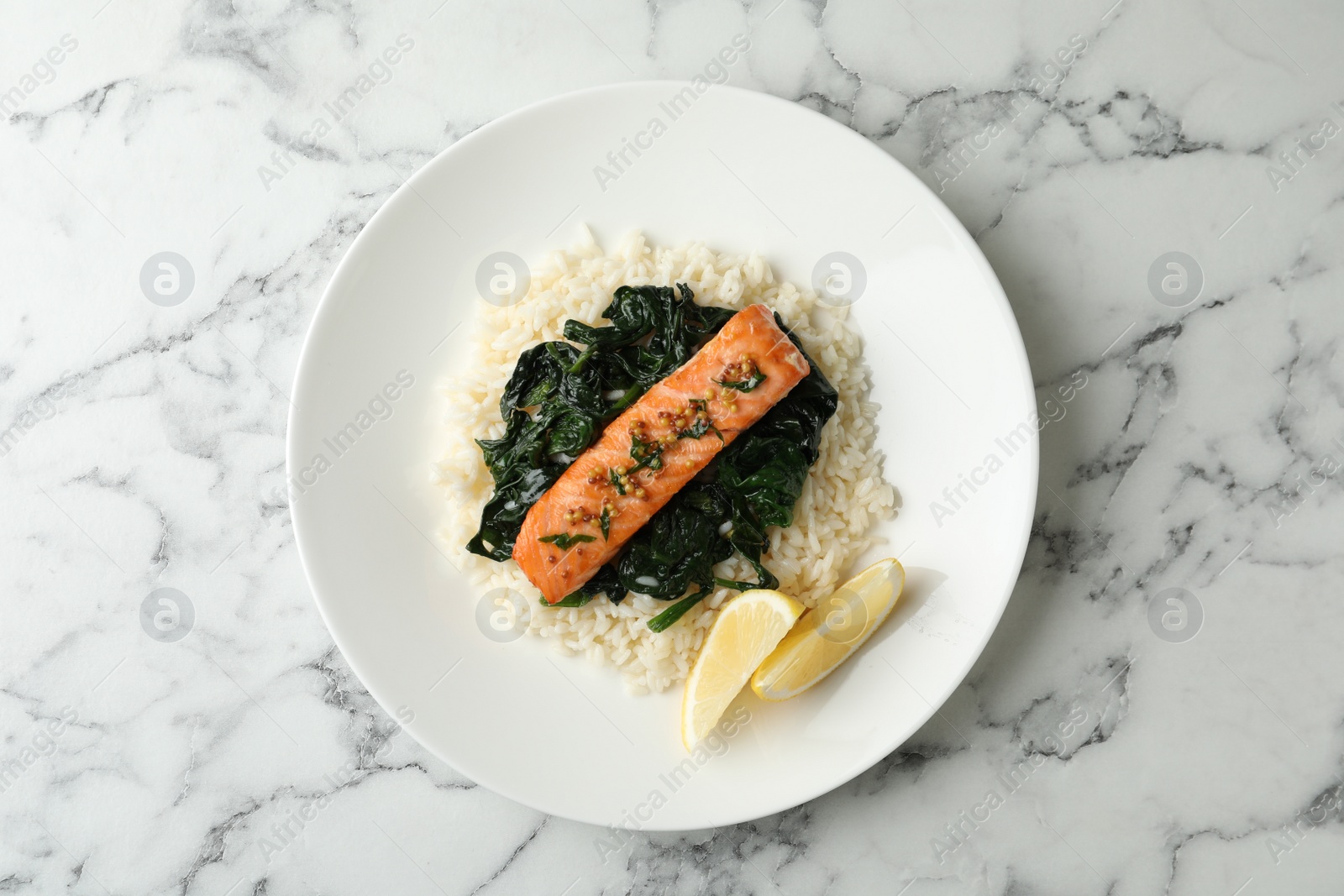 Photo of Tasty salmon with rice and spinach on white marble table, top view