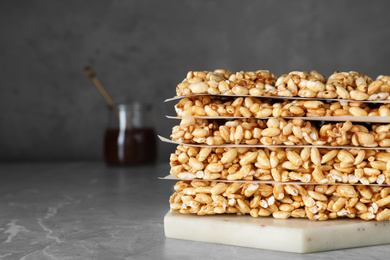 Photo of Delicious rice crispy treats on grey table, closeup. Space for text