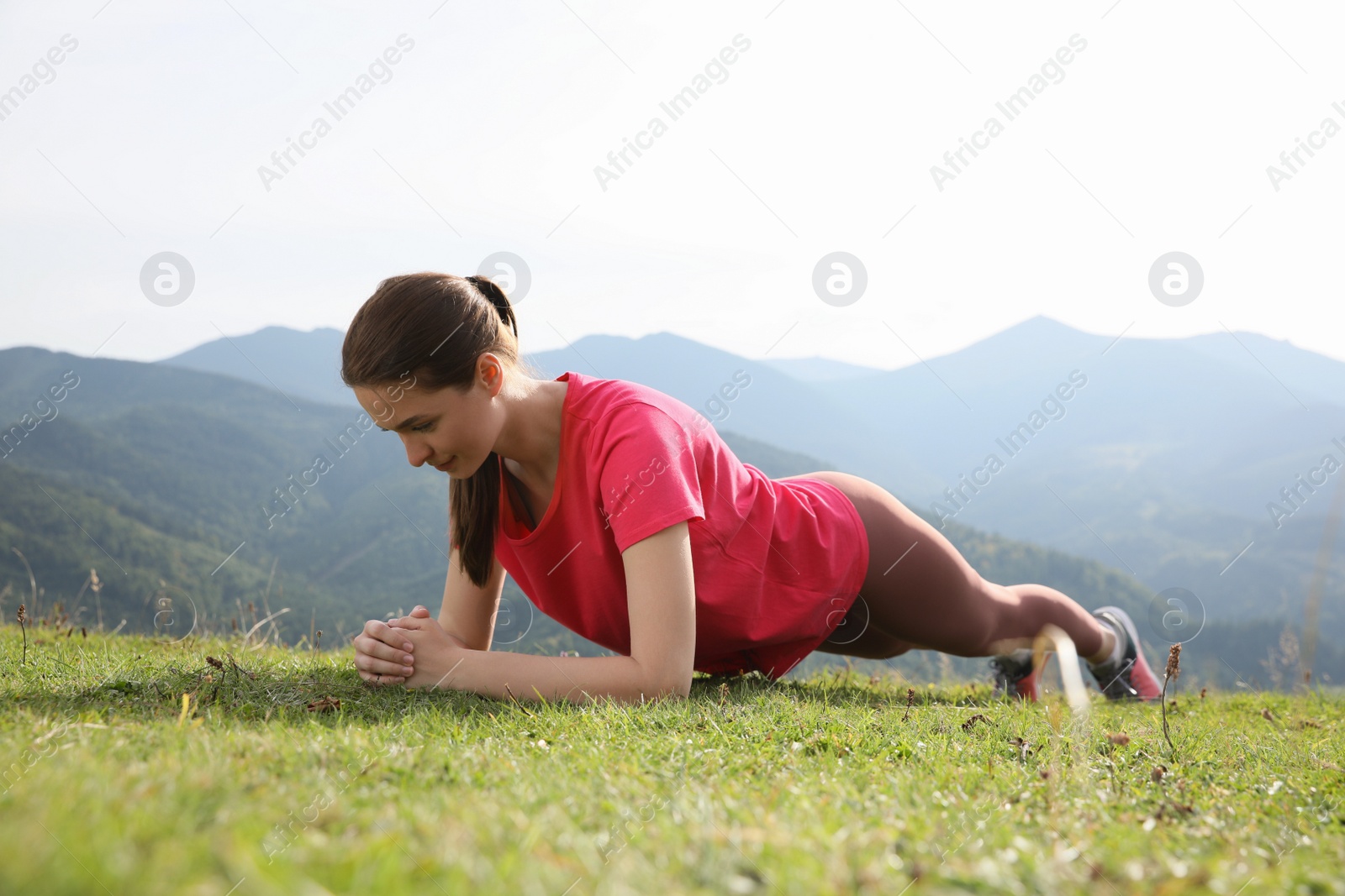 Photo of Young woman doing morning exercise in mountains