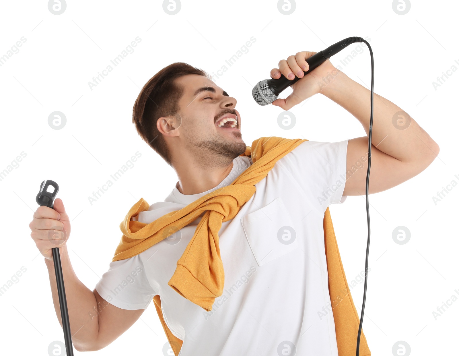 Photo of Young handsome man in casual clothes singing with microphone on white background