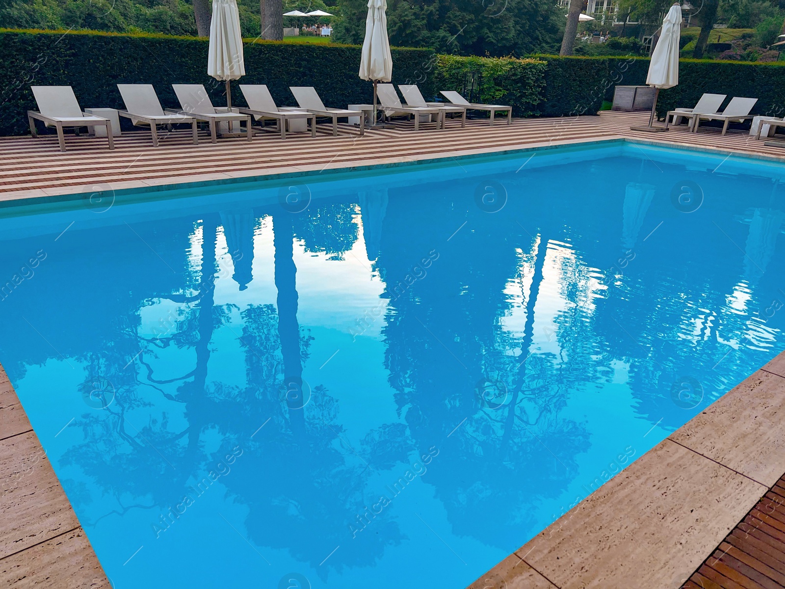 Photo of Outdoor swimming pool in luxury hotel on sunny summer day. Time for relax